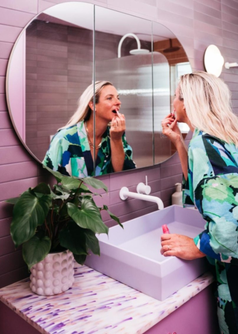 Nero Tapware’s white wall bath mixer in a purple bathroom