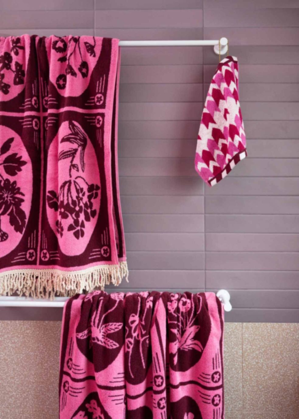 purple bathroom towels hung on Nero Tapware’s white towel rails